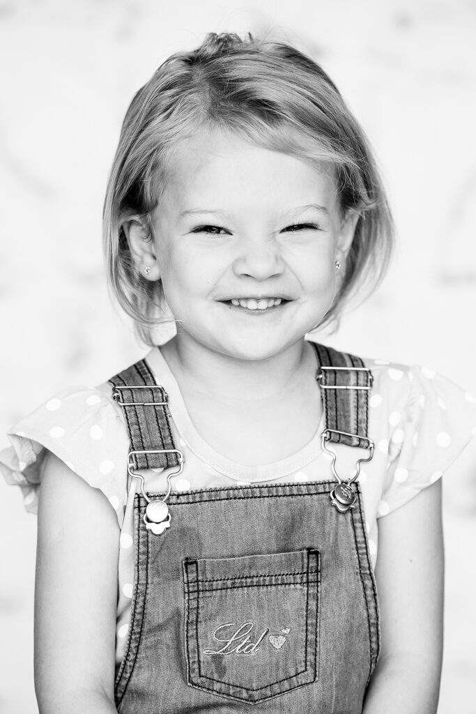Trimeless black & white child portrait, smiling toddler on geometric background shot by Kevin Mark Pass