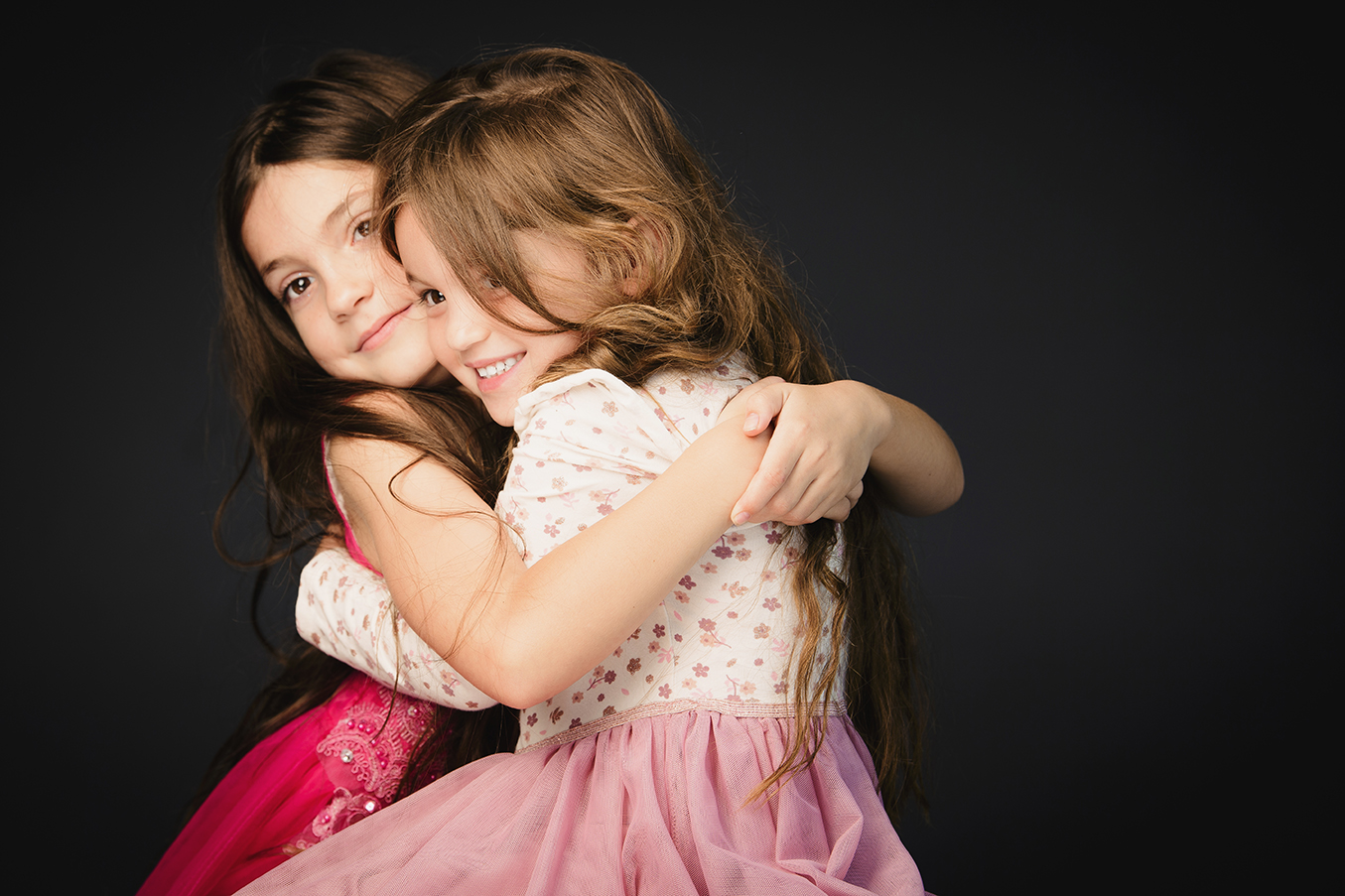 Moody background portrait of young sisters, shoot in studio by Kevin Mark Pass Photography
